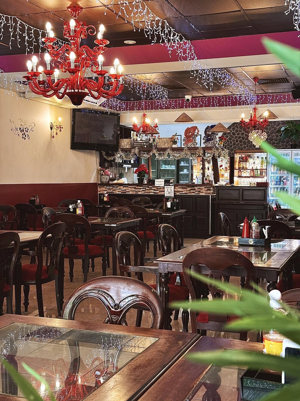 Non La's dining room with red chandeliers, dark wood chairs and the bar